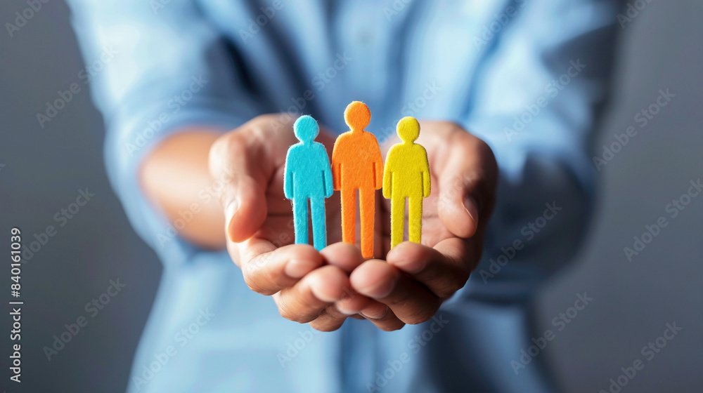 Person holding three silhouettes people in the palm of the hands connecting them